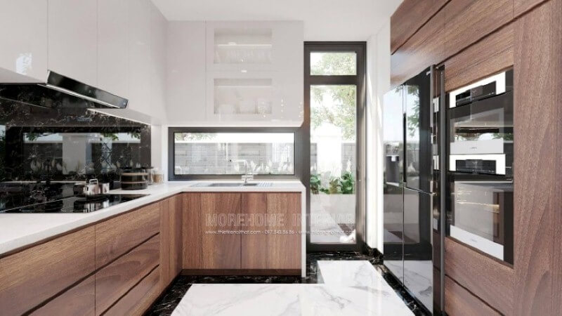 Là một trong những xu hướng trang trí nội thất nổi bật trong những năm tới, thiết kế phòng bếp hiện đại tôn lên vẻ đẹp mộc mạc nhưng không kém phần sang trọng của gỗ điển hình là gỗ óc chó tự nhiên. Loại gỗ rất được ưa chuộng trong các siêu xe bởi vẻ đẹp ấn tượng từ vân, màu gỗ. Như trong ý tưởng trang trí phòng bếp tại biệt thự Vinhomes Imperia Hải Phòng, sự hài hòa tôn lên nét đẹp giữa truyền thống và hiện đại, tủ bếp dưới gỗ óc chó và tủ bếp trên gỗ công nghiệp trắng bóng. Tủ bếp gỗ công nghiệp và tủ bếp acrylic